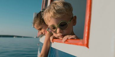 Two autistic children looking out a boat window 