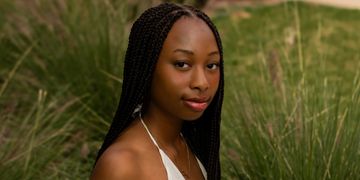 Portrait of a woman with braided hair outdoors.