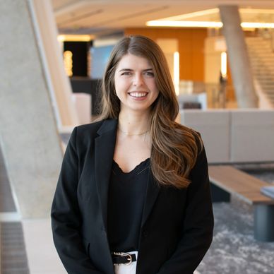 Professional woman in business attire smiling indoors.