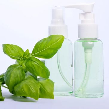 Bottles of skin care with fresh herbs.