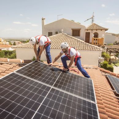 Workers installing solar panels on a roof.