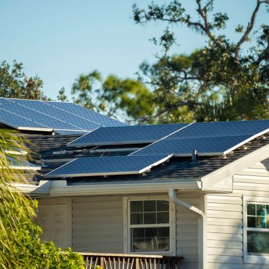 Solar panels installed on house roof under clear sky.