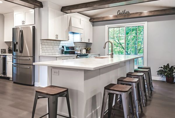 Modern kitchen with white cabinets and stainless steel appliances.