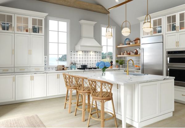 Bright white kitchen with wooden stools and pendant lights.