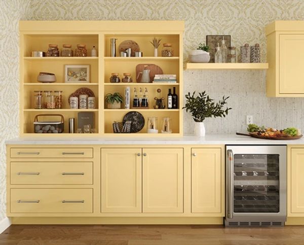 Yellow kitchen cabinets with open shelves and wine cooler.