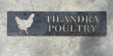 Metal sign with a chicken silhouette and 'Tilandra Poultry' text.
