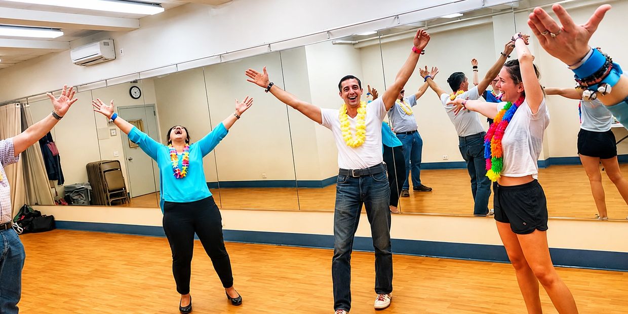 People joyfully stretching arms in a dance studio with colorful leis.