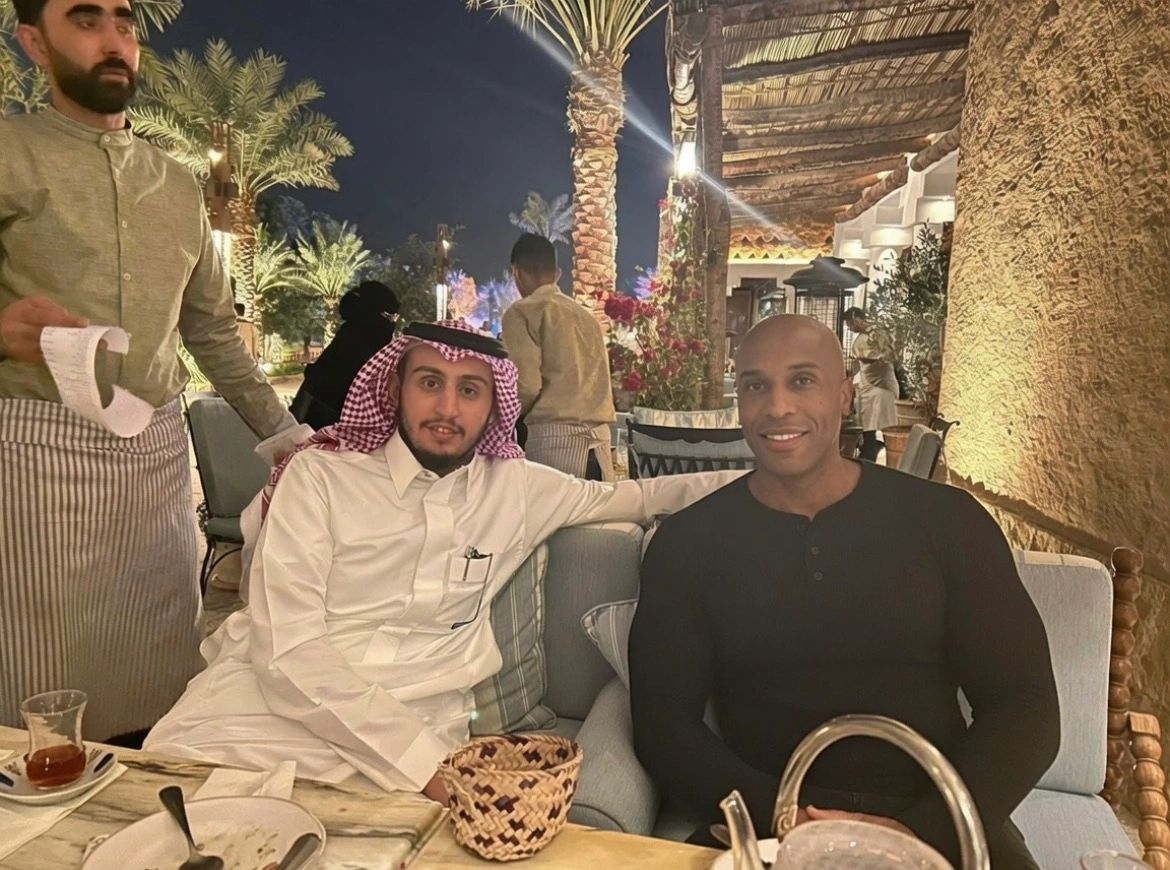 Two men sitting in a cozy outdoor restaurant at night.