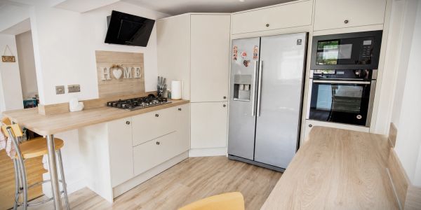 Modern kitchen with light wood and white cabinets.