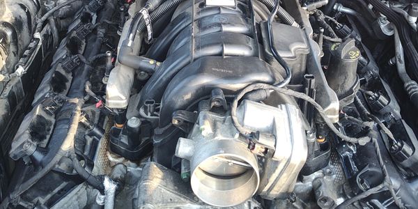 Close-up of a car engine with visible throttle body.