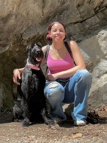 Lenni Wolfe posed next to her Giant Schnauzer P at the base of a mountain