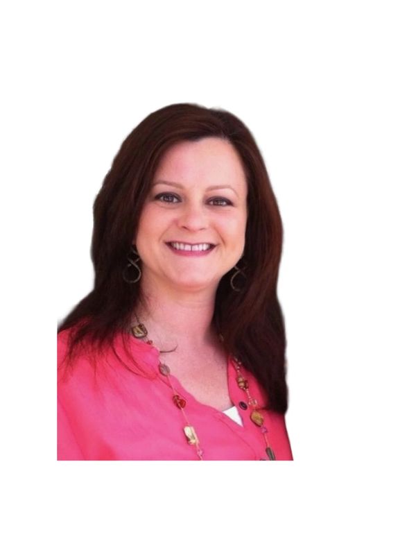 Smiling woman with dark hair wearing a pink blouse and necklace.