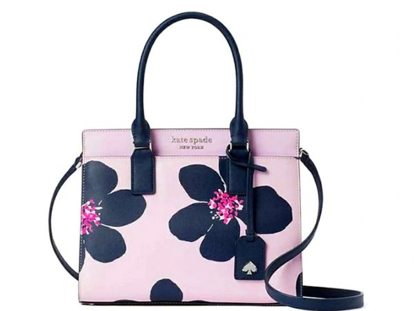 Pink handbag with large black flowers and navy handles.