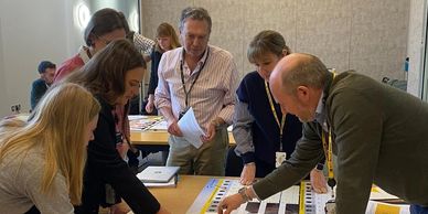 Group of people collaborating around a table with documents and charts.