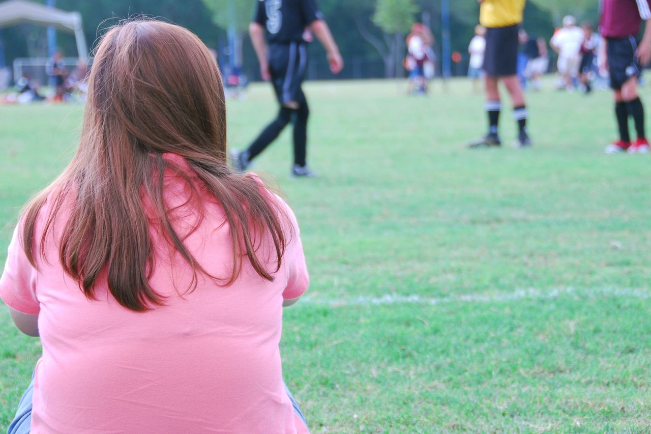 Women sitting on the sidelines of a soccer game
