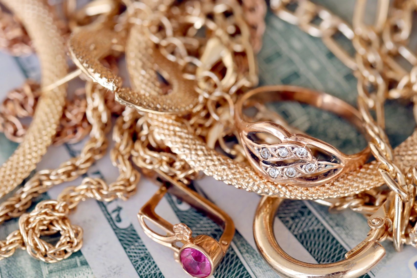 Close-up of gold jewelry on cash notes.