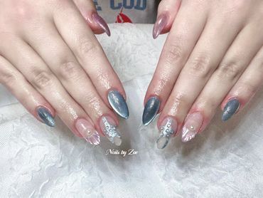 Elegant blue and pink nails with pearl and rhinestone accents.