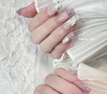 Elegant nails with pastel shades and rhinestone accents.
