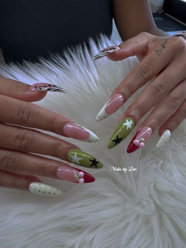 Colorful long stiletto nails with stars, cherries, and animal print designs.
