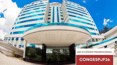 Modern multi-story building with blue-striped windows under a clear sky.