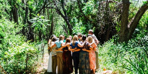 Group hug in a forest path.
