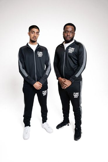 Two men in matching black tracksuits with "PURE VIBES ENT" logos.