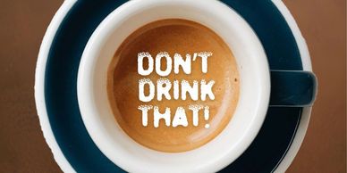 A coffee cup with 'DON'T DRINK THAT!' written in the foam.