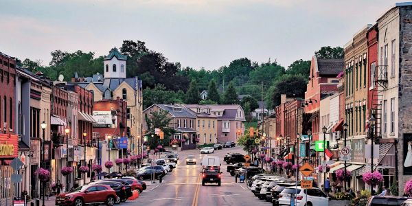 Charming small town street lined with historic buildings and parked cars.