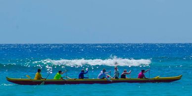 Teamwork: group of people in an ocean canoe