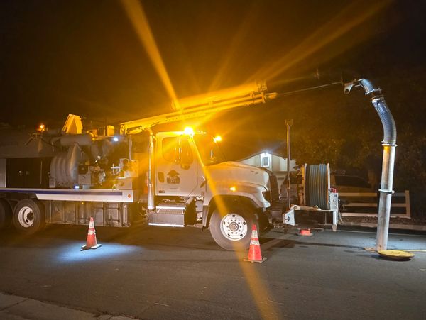 Jet-vac truck working at night with strobe lights flashing. 