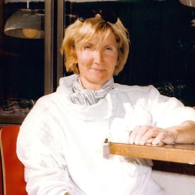 Person wearing white, seated and relaxed indoors.