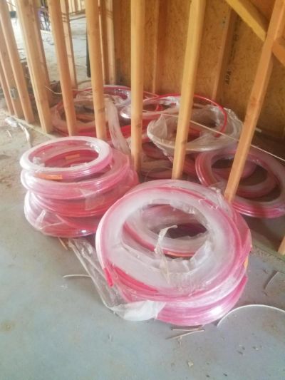 Coiled pink plastic tubing on a construction site floor.