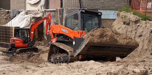 Skis Steer and excavator moving sand 