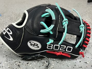 Black baseball glove with turquoise laces and red accents.