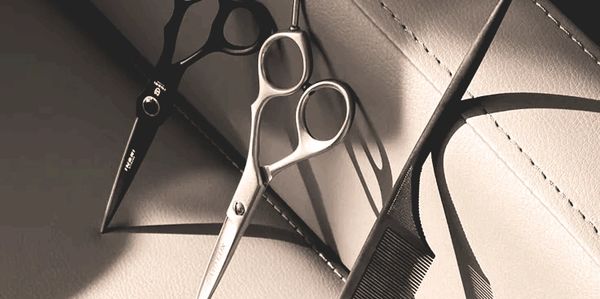 Ciseaux de coiffure et peigne posés sur une surface.