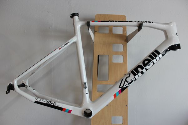 White Cinelli bike frame on a wooden stand.