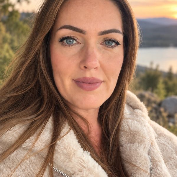 Woman in a cozy jacket outdoors at sunset.