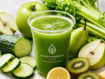 Green smoothie surrounded by fresh fruits and vegetables.