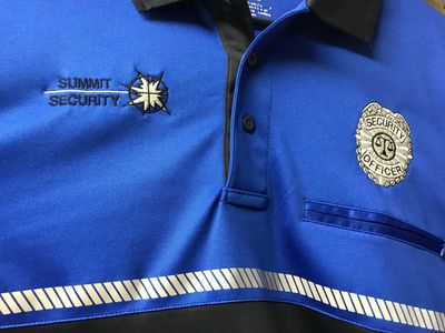 Blue security officer uniform with Summit Security logo and badge.