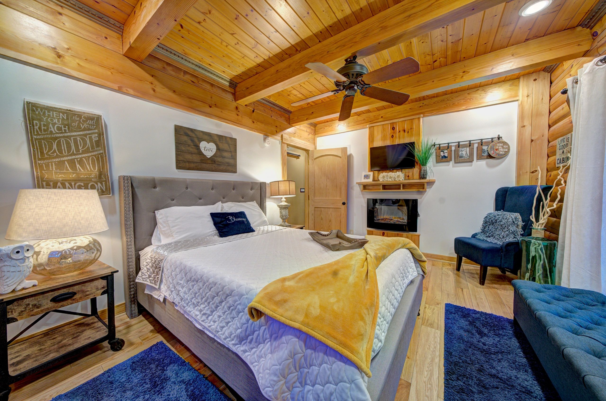 Cozy rustic bedroom with wooden ceiling and modern decor.