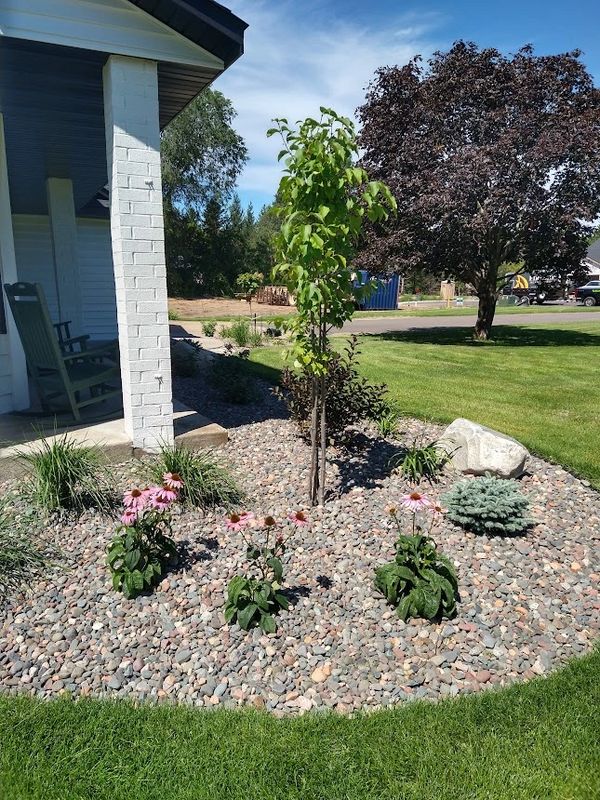 Foundation landscape renovation with decorative rock and flowering perennials and ornamental grasses