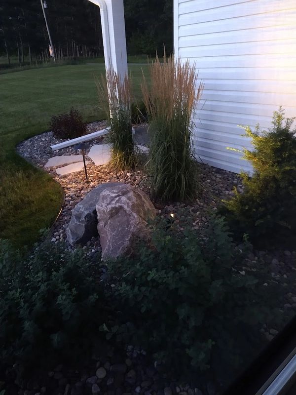 Landscape pathway lighting with boulder outcropping and ornamental grasses