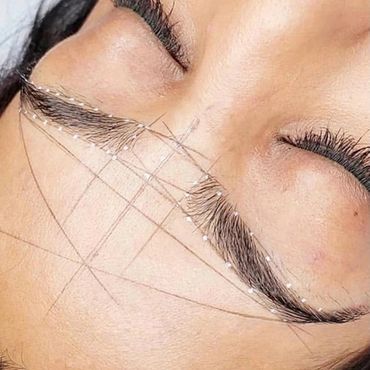 Close-up of eyebrow shaping with string technique.