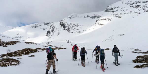 Group hiking in snowy mountain landscape.