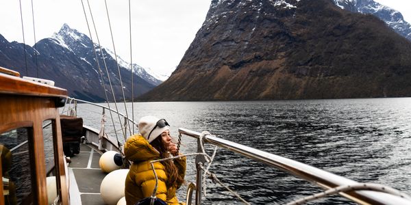 Person enjoying a boat ride in snowy mountains.