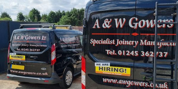 Two black vans with A &amp; W Gowers signage and hiring notices.