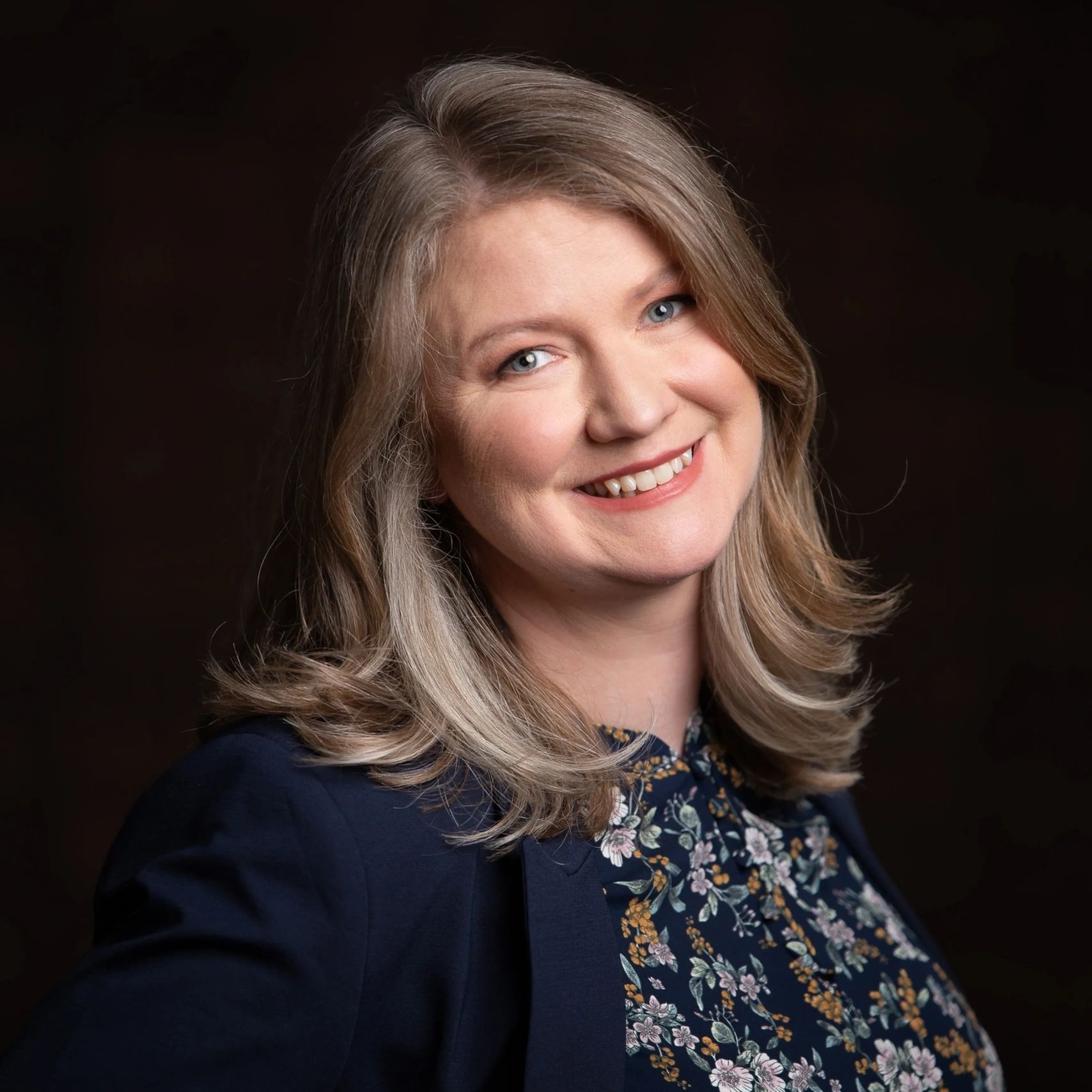woman in floral shirt and blue jacket 