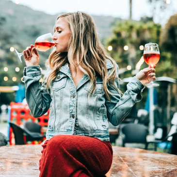 Wine Events & Festivals Young Blonde Woman Drinking two glasses of Rose, while sitting outside.