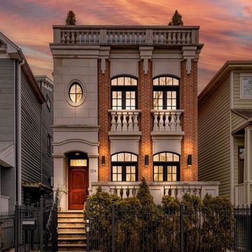Elegant two-story brick and stone house at sunset.