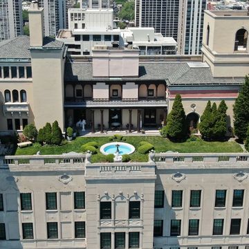 Rooftop garden with a fountain in an urban setting.